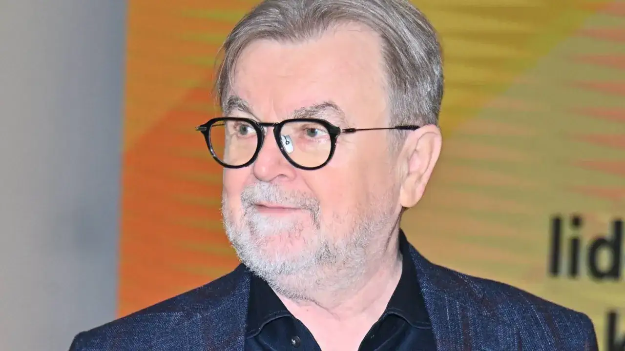 Edward Miszczak wzrost. Mężczyzna w okularach, z siwą brodą i włosami, w granatowej marynarce.