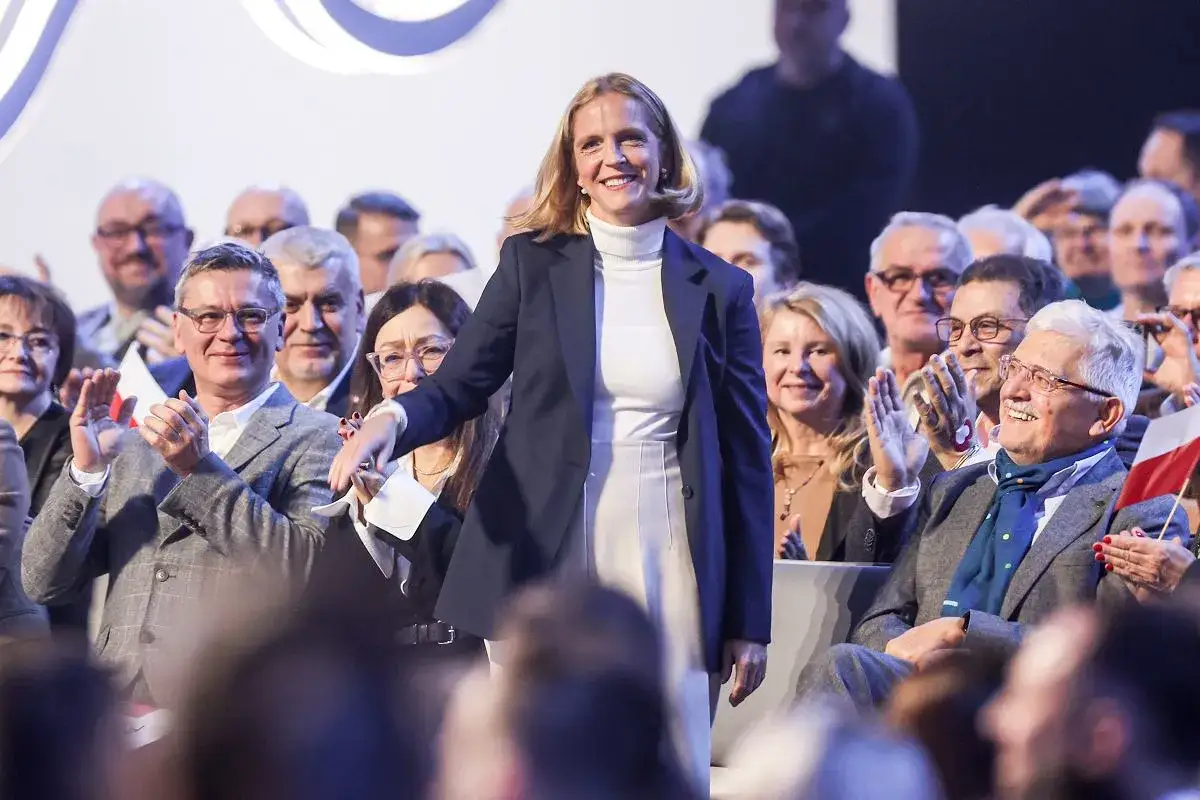 Małgorzata Trzaskowska, z jej wykształceniem, przemawia do zgromadzonych. Ludzie klaszczą, wyrażając aprobatę.