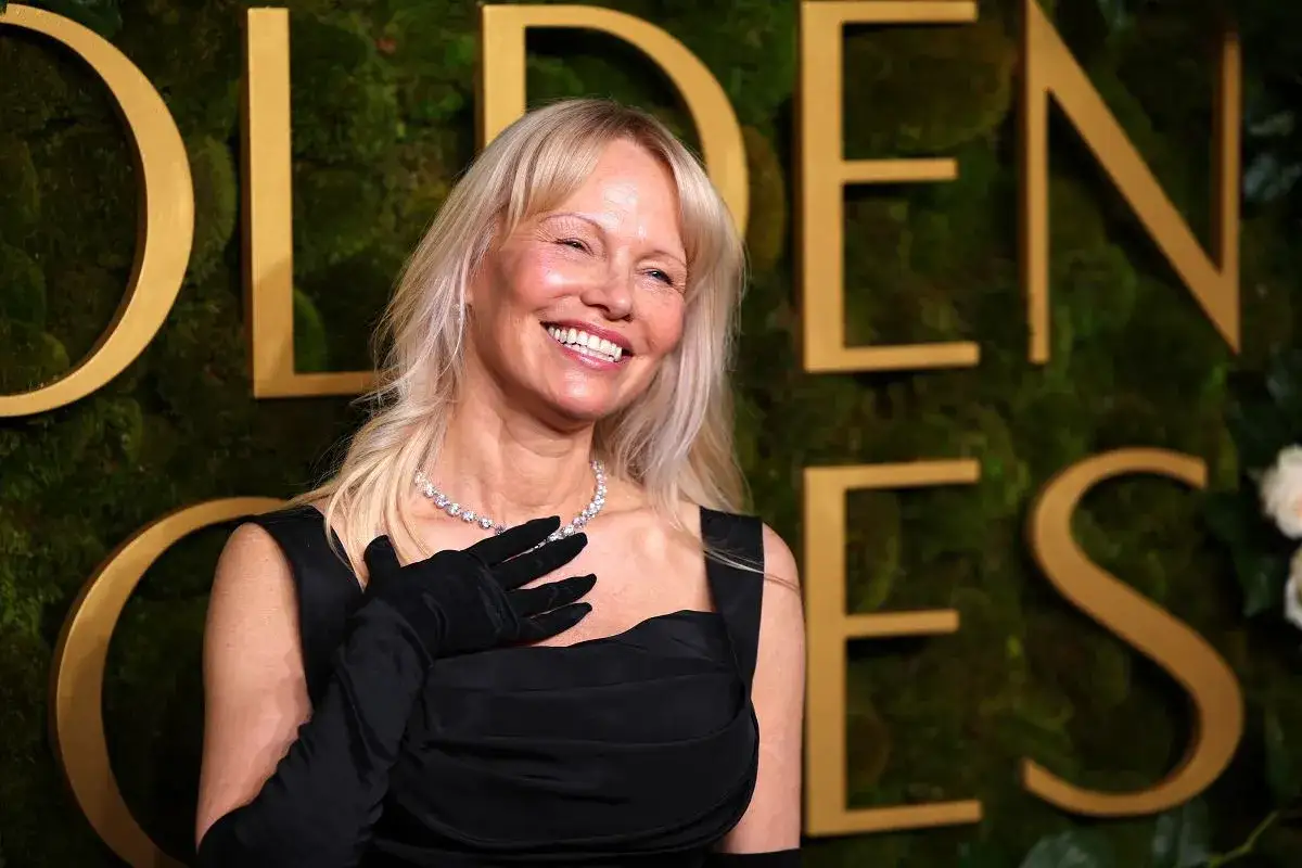 Pamela Anderson, gwiazda, która zawsze budzi sensację, uśmiecha się na ściance. Jej stylizacja i obecność to zawsze temat plotek.