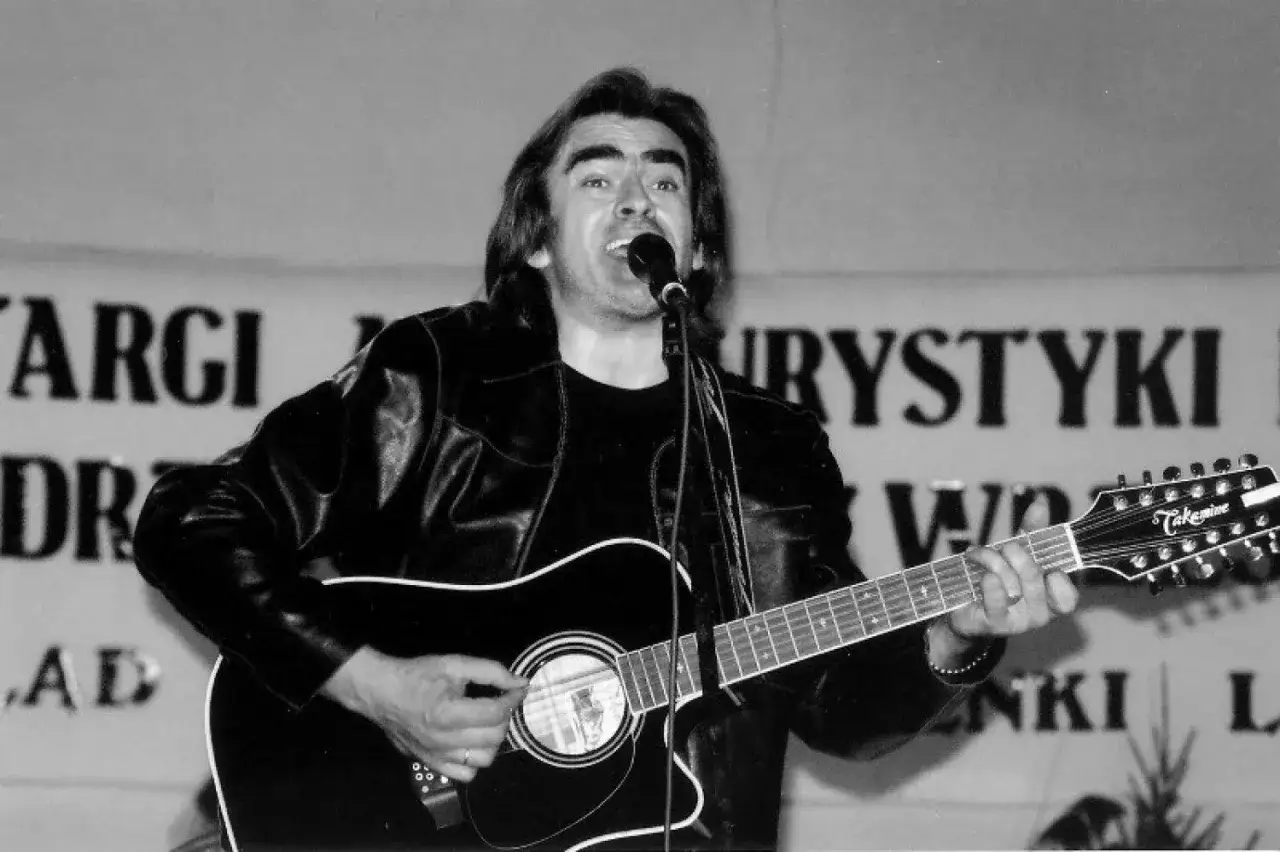 Witold Paszt nie żyje. Wokalista śpiewa i gra na gitarze dwunastostrunnej na scenie.
