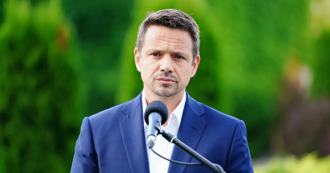 Rafał Trzaskowski przed mikrofonem, w tle zieleń. Ile dzieci ma Trzaskowski? Dwoje.