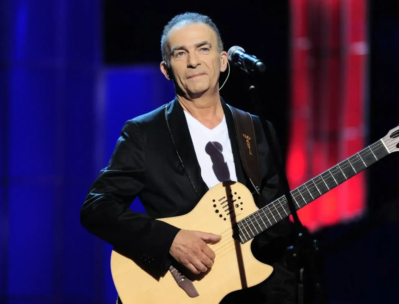 Artysta Seweryn Krajewski nie żyje. Wokalista i gitarzysta na scenie, w czarnym garniturze, z gitarą.