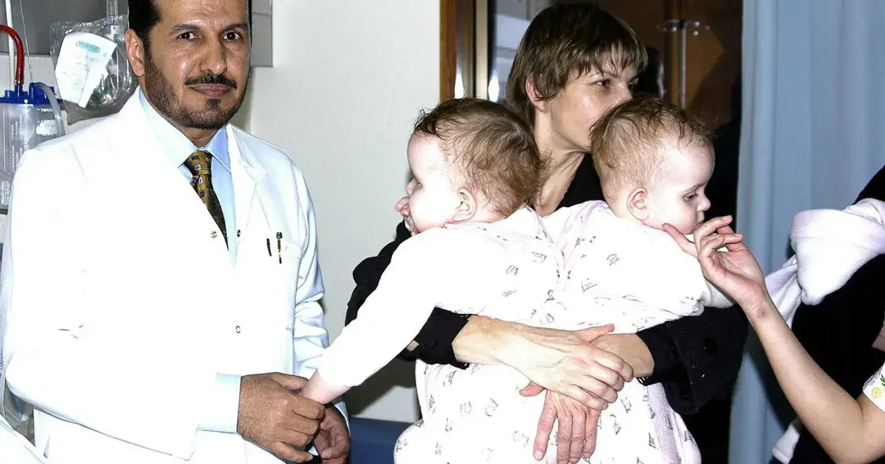 Lekarz w białym kitlu trzyma za rękę jedną z bliźniaczek syjamskich z Janikowa, które obejmuje matka.