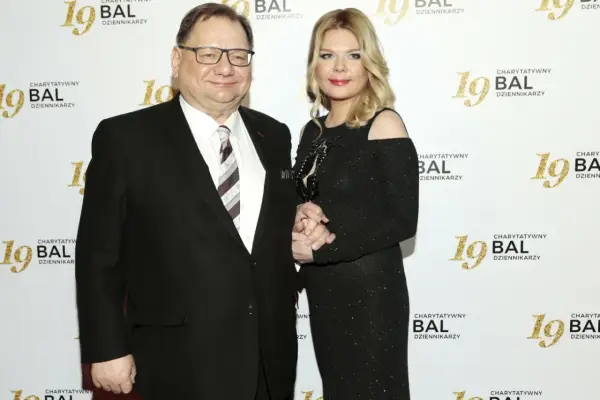 Dominika Lis, w wieku około 40 lat, w czarnej, błyszczącej sukni, stoi obok starszego mężczyzny w garniturze.
